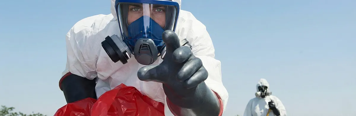 sewage clean up technician wearing protective gear handling biohazard materials in Charlotte, NC